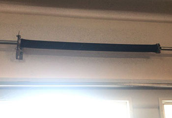 Close-up of snapped torsion spring on residential garage door in Mound, MN before spring replacement.