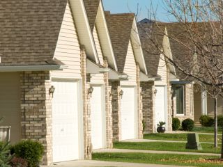 Row of suburban homes in Chaska, MN featuring well-maintained white garage doors and tidy front yards, representing Garage Door Repair services.