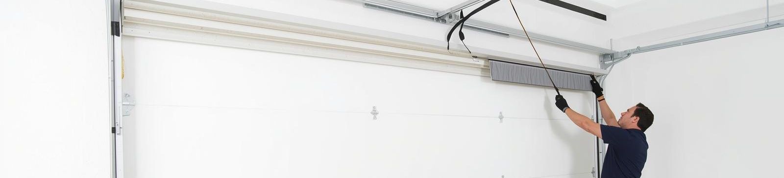 Professional technician installing a new white garage door in Chaska, MN residential garage