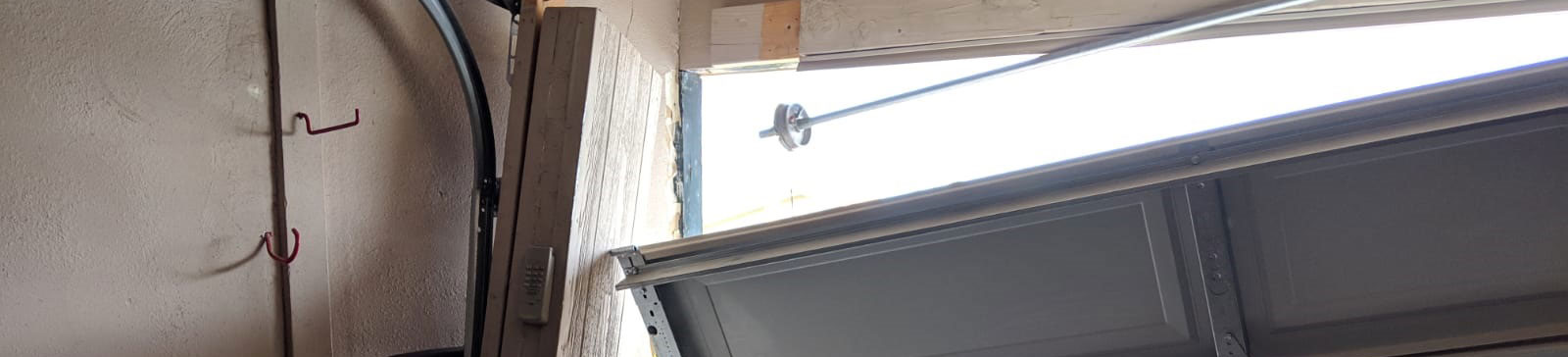 Severely damaged and misaligned sectional garage door before replacement at a Shakopee, MN residential property.